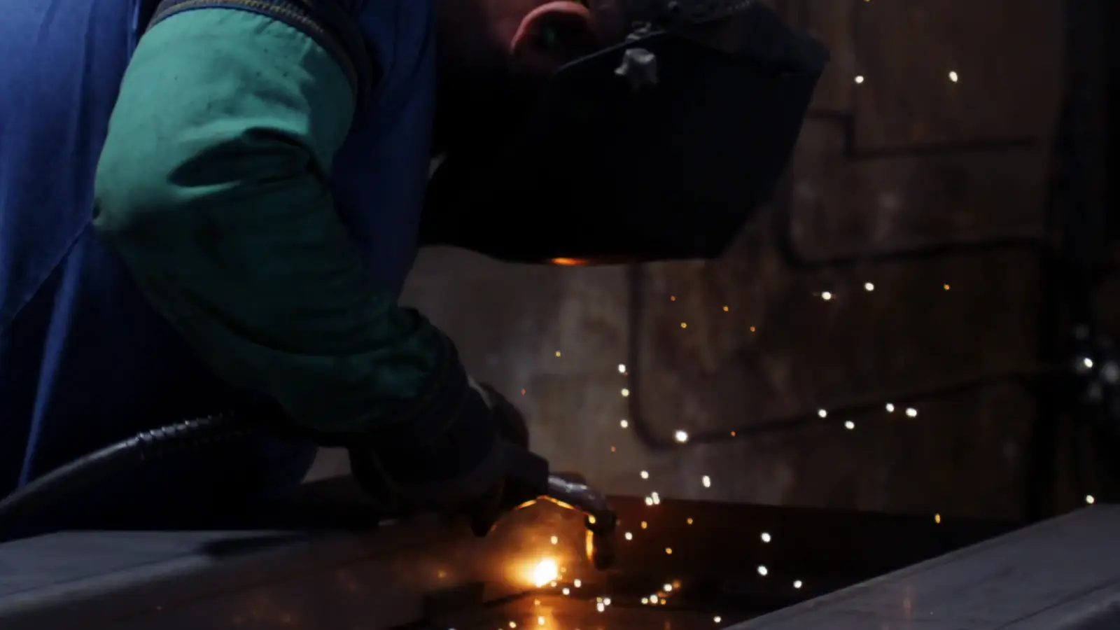 Bright blue MIG welding arc joining a steel weldment at Evans