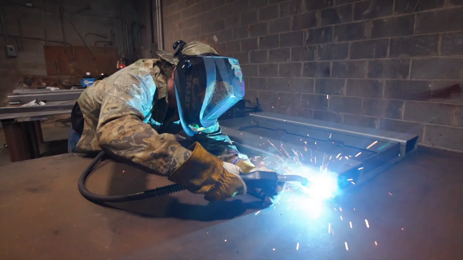 Welder in fatigues fabricating a steel assembly for a defense program