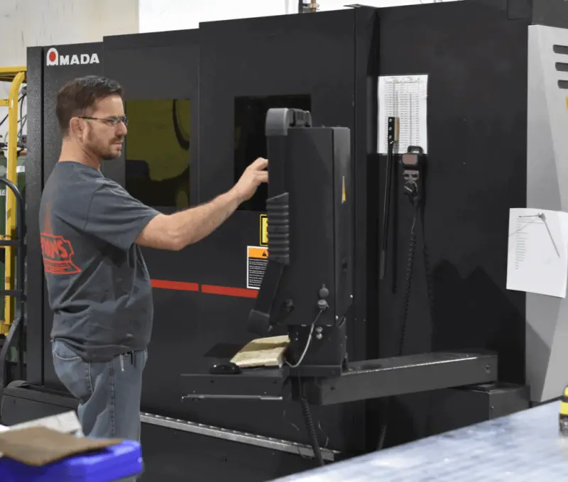 Evans technician operating the AMADA 6KW fiber laser