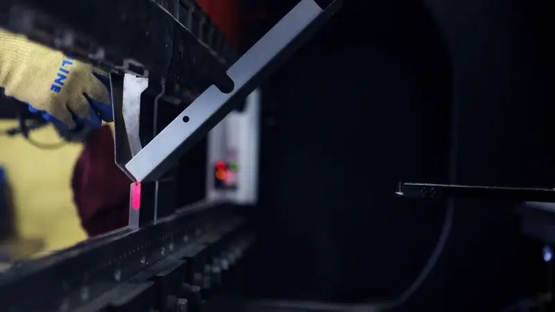 Operator aligning a part on the press brake under a laser guide line