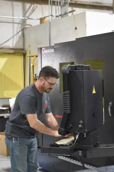 Evans technician programming a cut at the AMADA fiber laser control panel